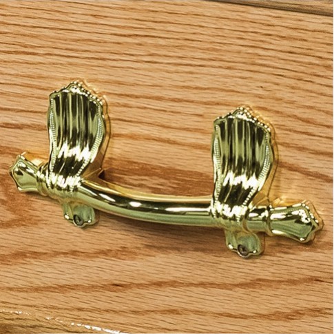 Polished brass bar handle on ornate scroll brackets, mounted on the solid oak side of The Derby