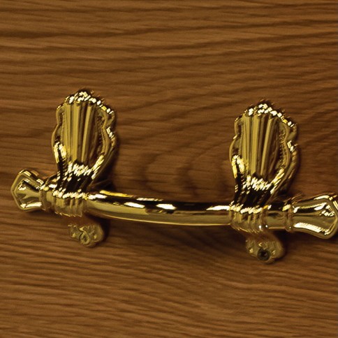 Polished brass bar handle on ornate scroll brackets, mounted on the side of The Hardwick